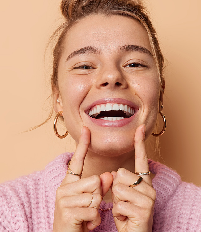 Frau mit perfektem Lächeln -Symbolbild für Bleaching in der Zahnarztpraxis Kowadent in Gerderath